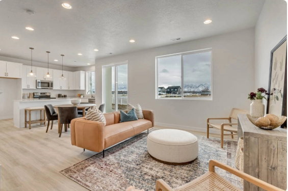 Open-concept living space featuring light wood-finish flooring, recessed lighting, and large windows. These pictures are of another home