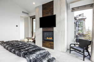 Built-in fireplace with a dark metal surround, integrated into a floor-to-ceiling accent wall featuring vertical wood paneling and stone-look tiling