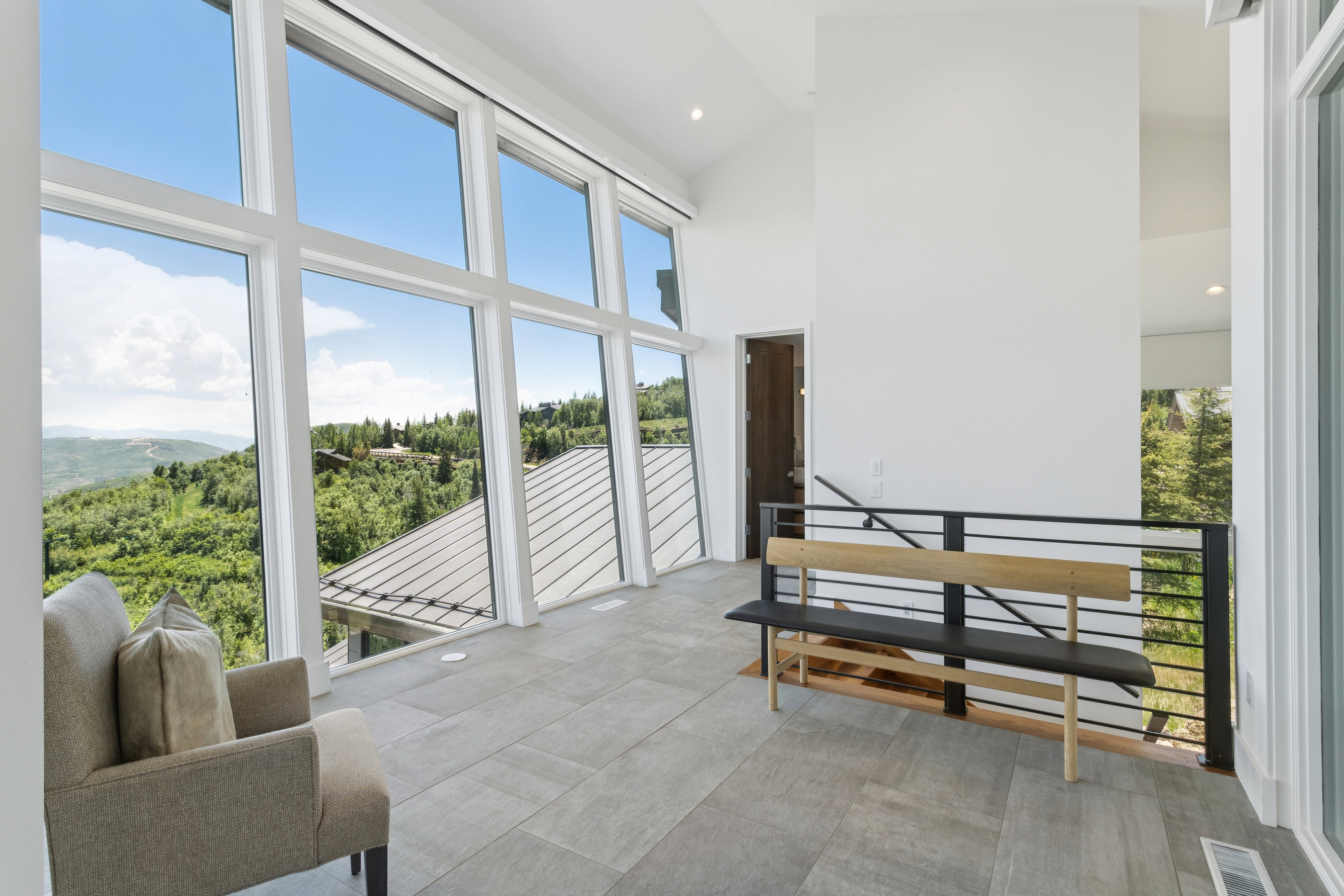 Expansive window wall with mountain and forested landscape