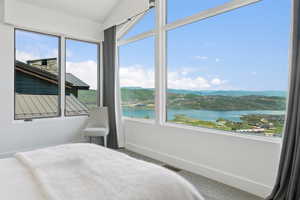 Expansive window wall with white trim framing distant water and mountain scenery