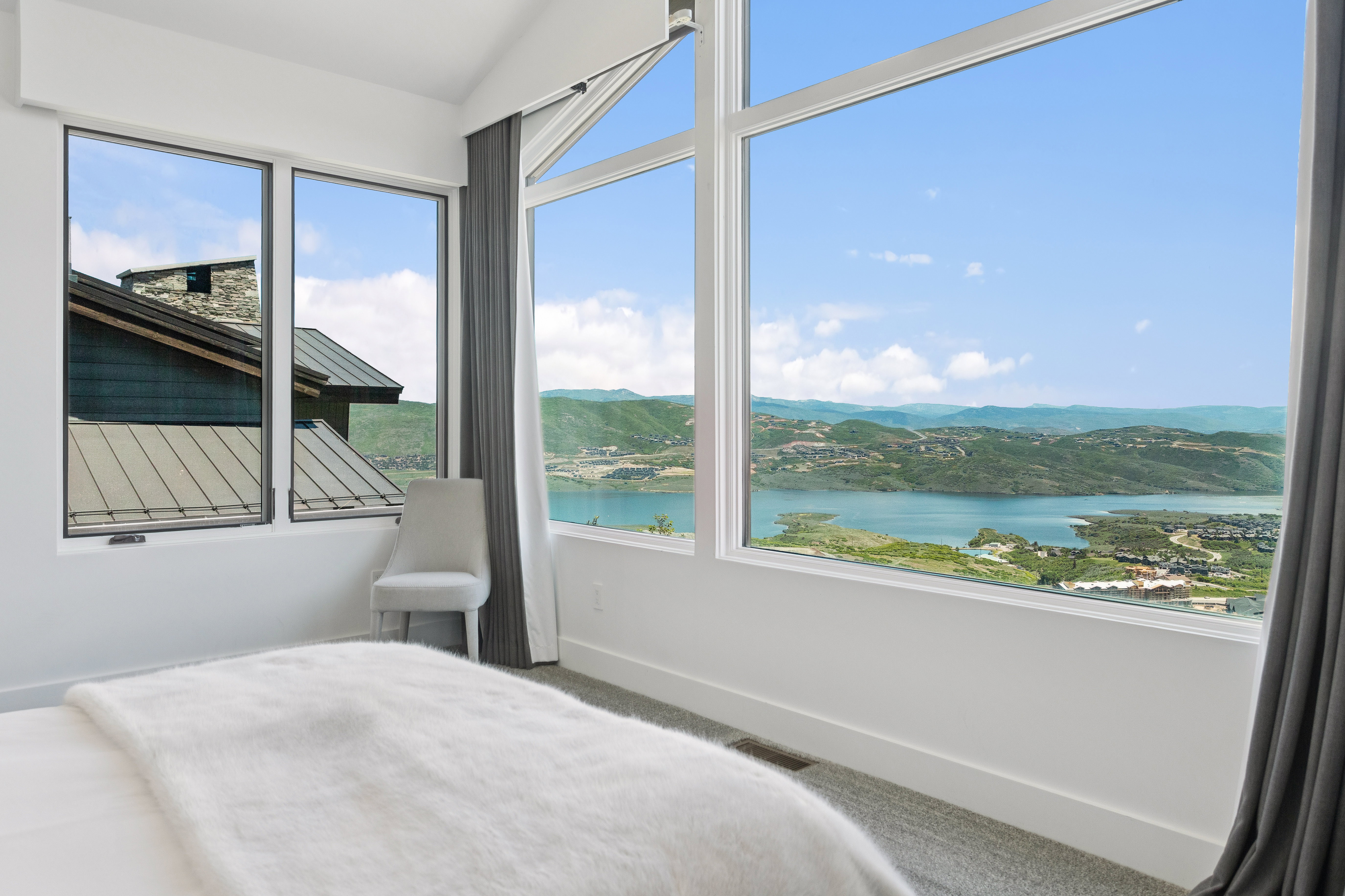 Expansive window wall with a water and mountain landscape