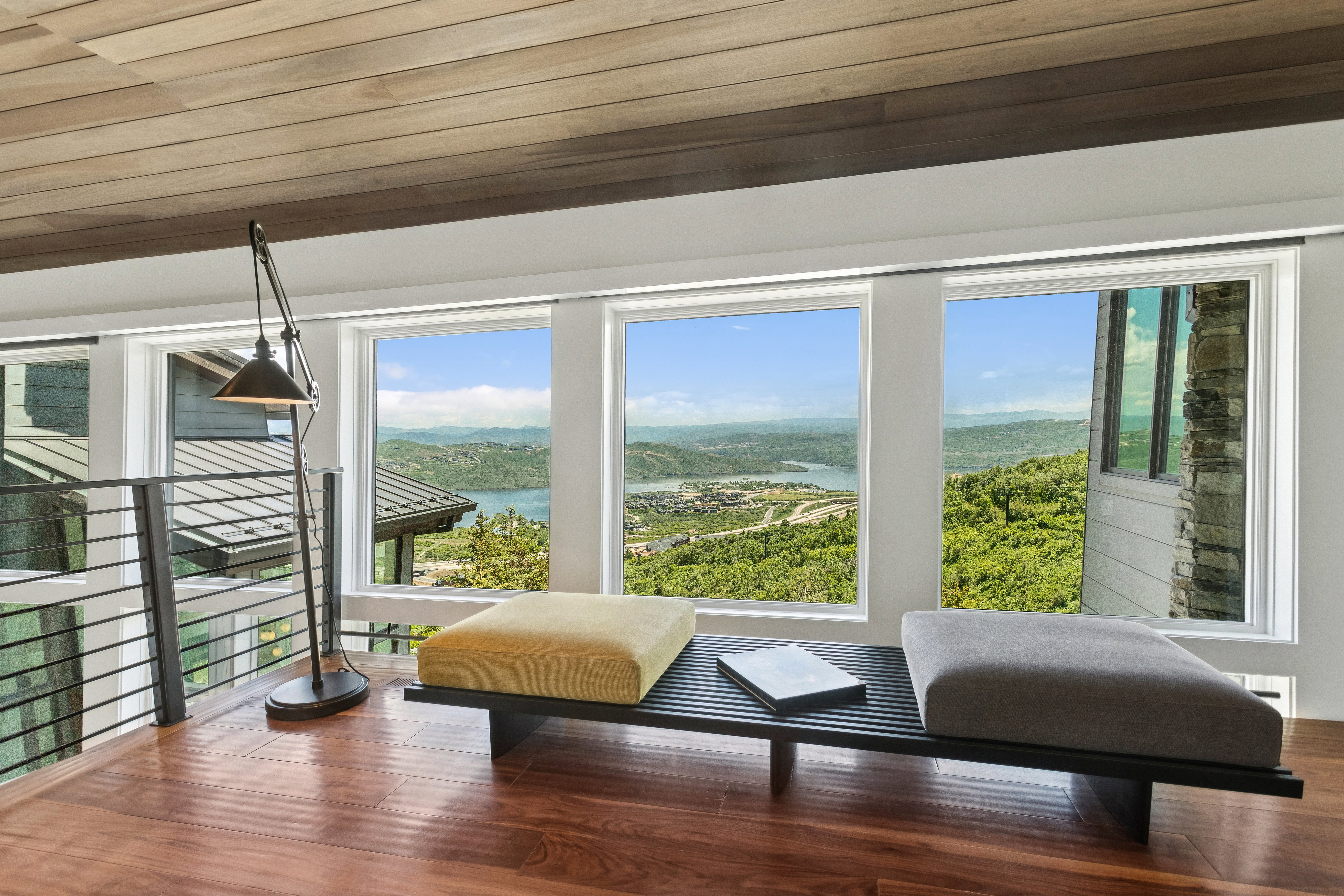 Expansive window wall overlooking mountainous terrain and a lake