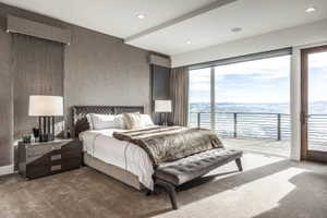 Room with floor-to-ceiling windows and sliding glass door opening to an outdoor patio with a metal railing