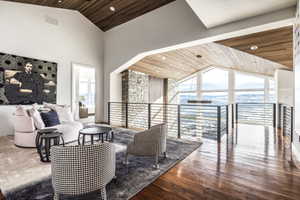 Open concept upper level featuring vaulted ceilings with wood paneling