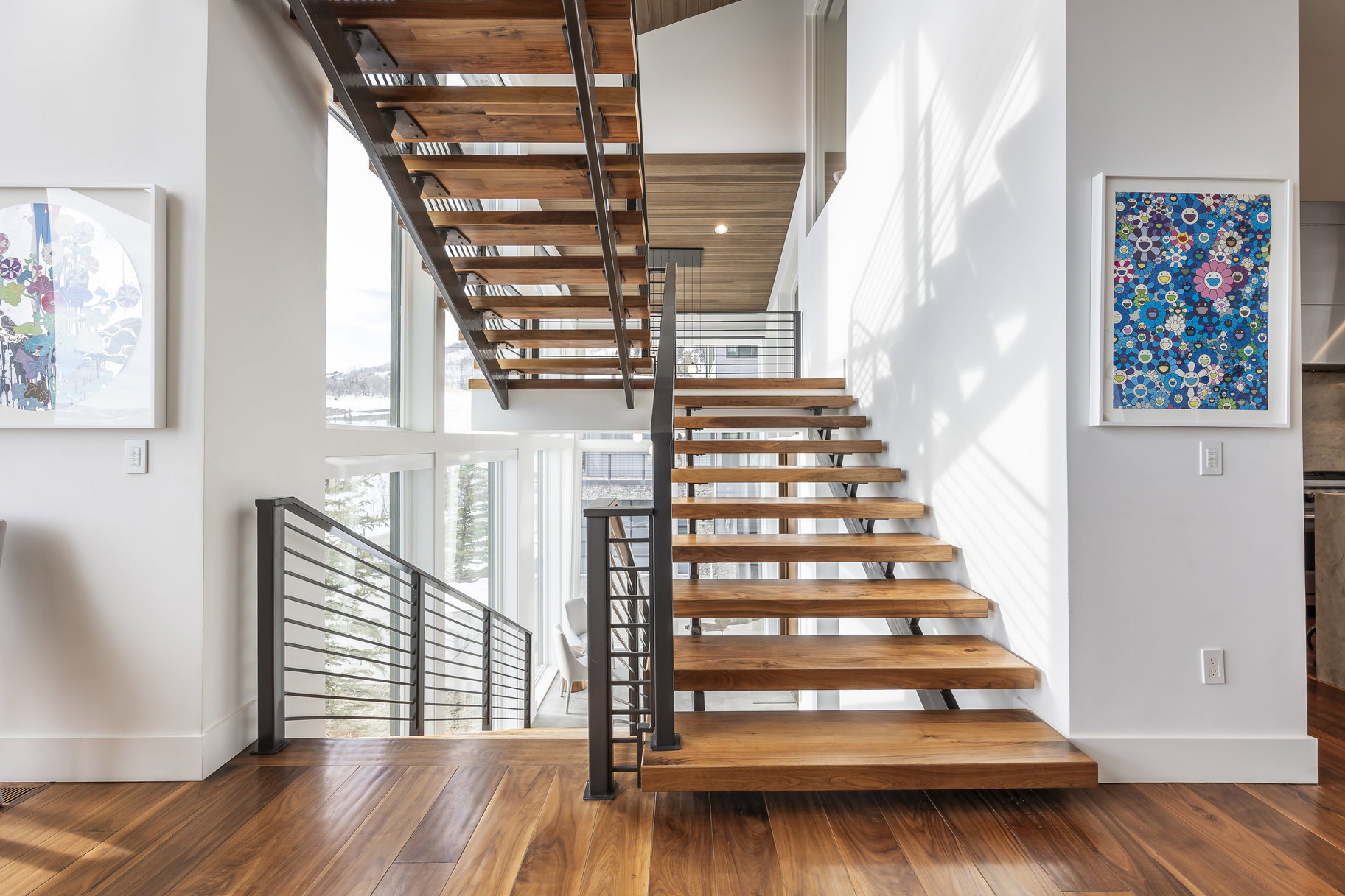 Open-tread staircase featuring wood-finish steps and metal railings