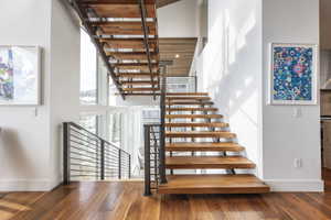 Open-tread staircase featuring wood-finish steps and metal railings