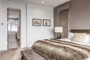 Bedroom with textured accent wall and broadloom carpeting