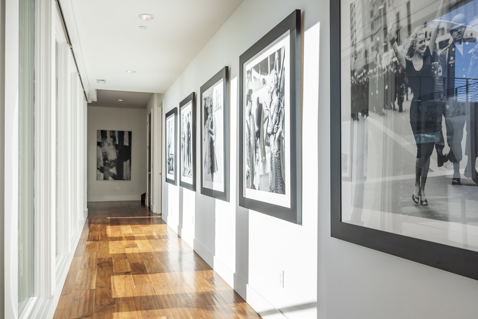 Hallway featuring wood-finish flooring, recessed lighting, and a window wall with vertical framing elements