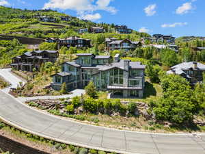 Modern multi-level home with extensive glazing, stone accents, and a metal roof