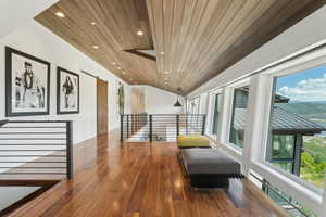 Hardwood flooring and wood-paneled ceiling with recessed lighting