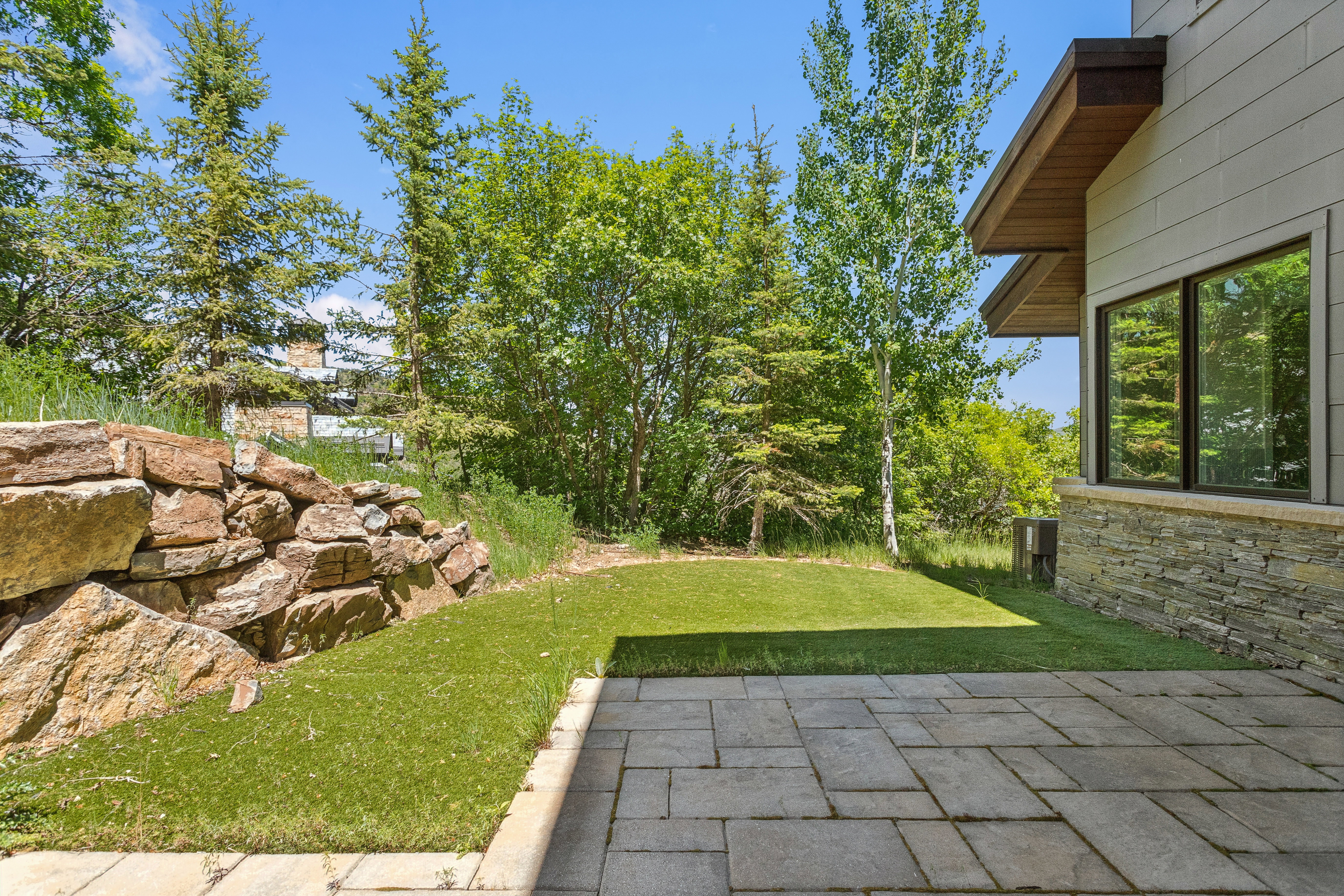 Stone paver patio with a turf lawn border
