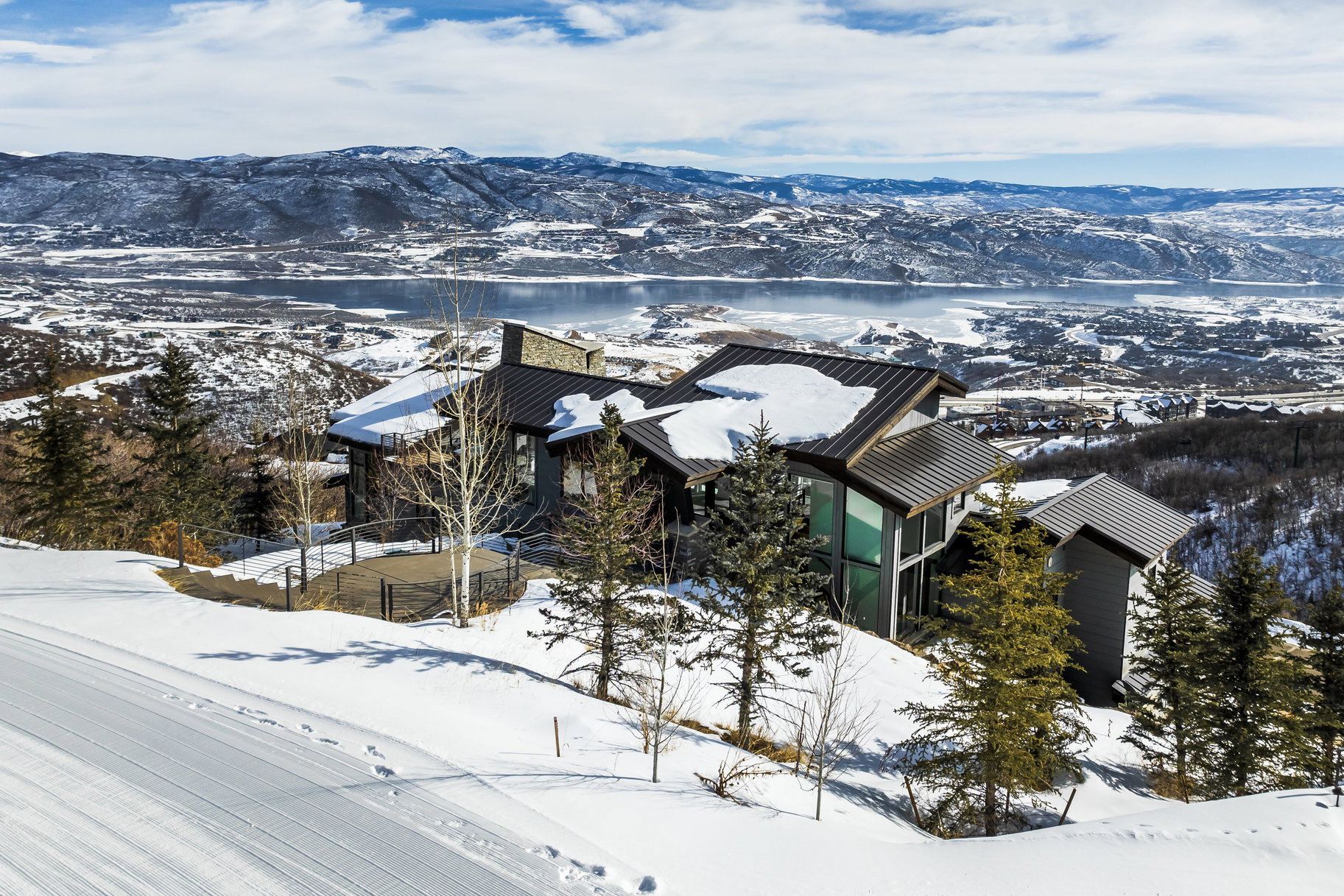 Modern sloped-roof architecture featuring dark siding and expansive windows