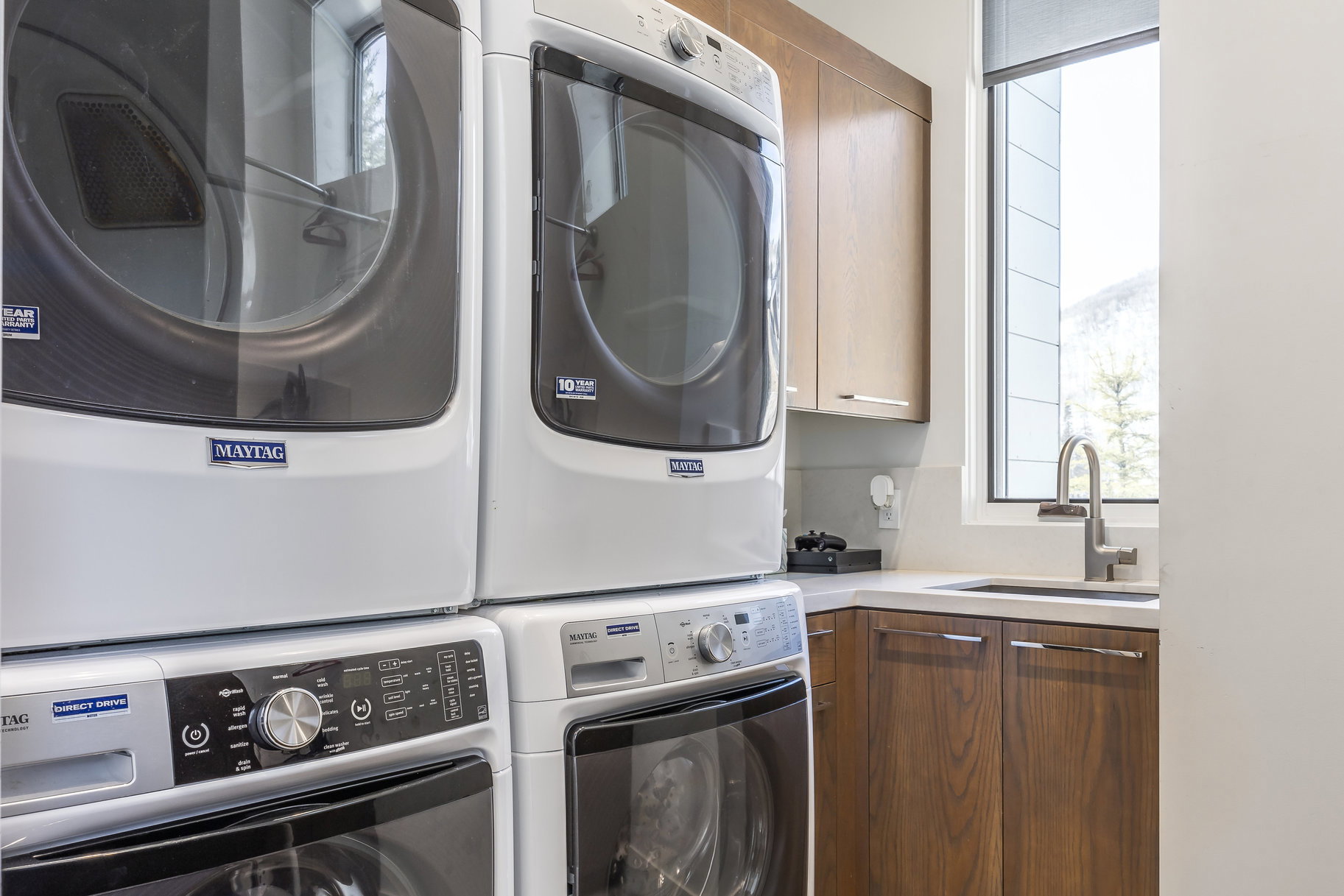 Dedicated laundry area featuring stacked front-load washer and dryer units