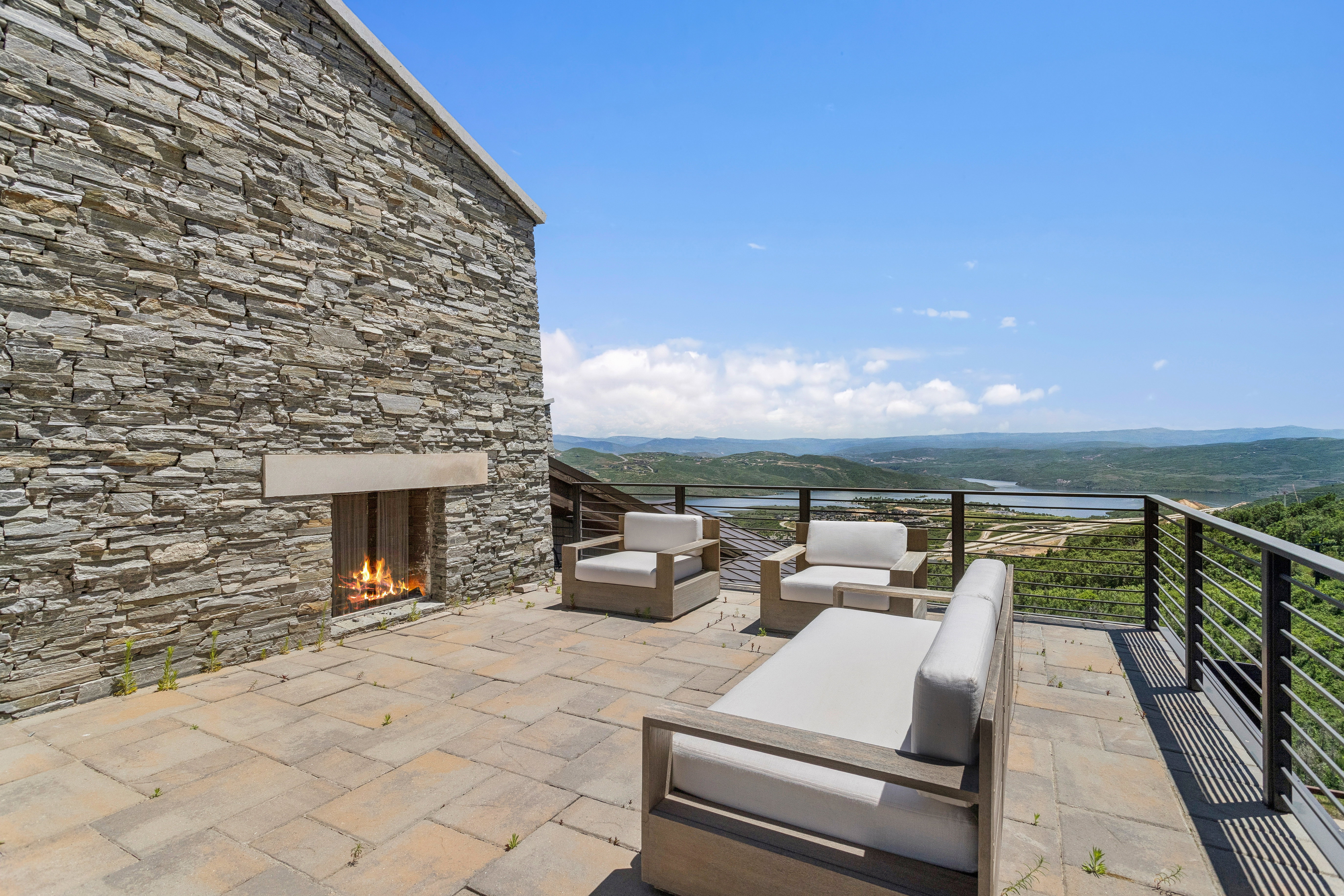 Stone exterior featuring an outdoor fireplace with a stone mantel