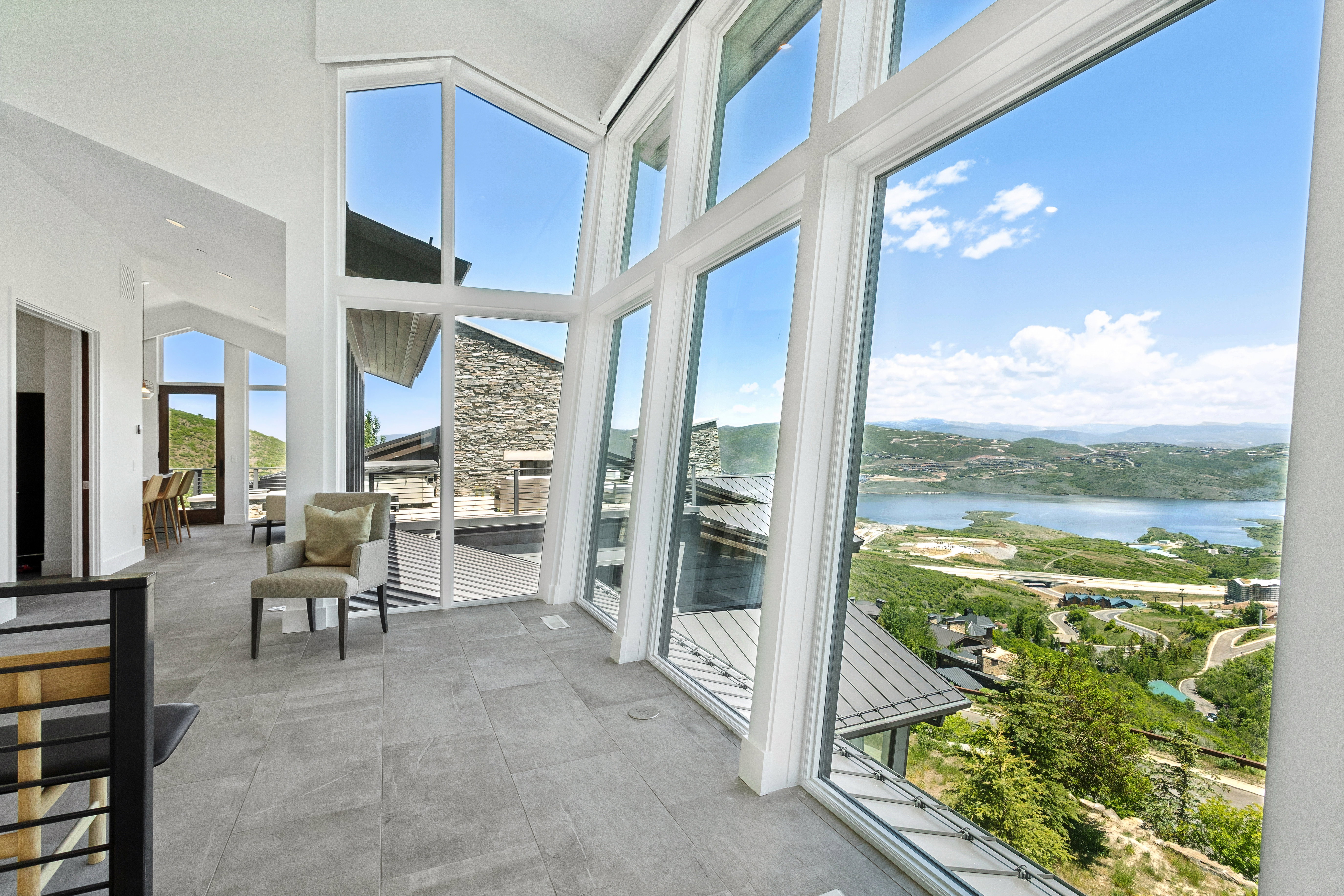 Expansive window wall with a prominent lake and mountain backdrop
