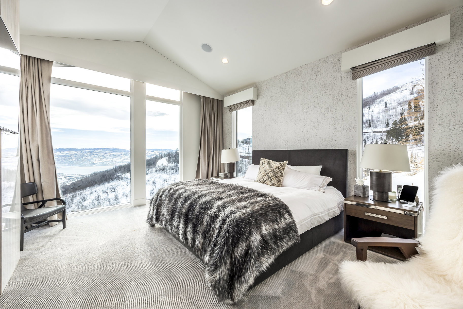 Carpeted bedroom with a vaulted ceiling, floor-to-ceiling windows, and integrated recessed lighting