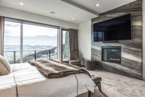 Spacious bedroom with expansive window walls framing a snowy mountain backdrop