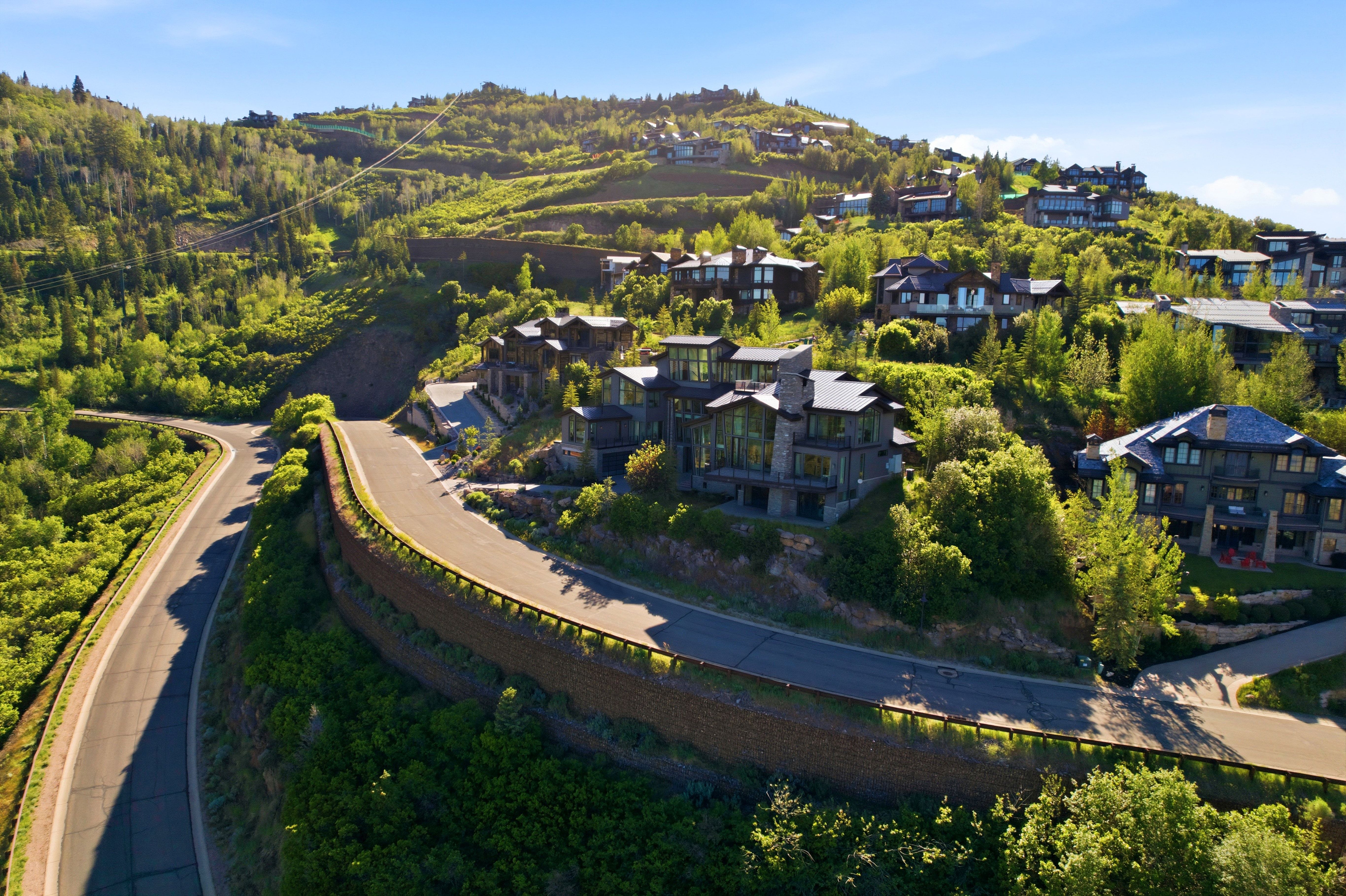 Hillside property with natural stone exterior and extensive glass windows