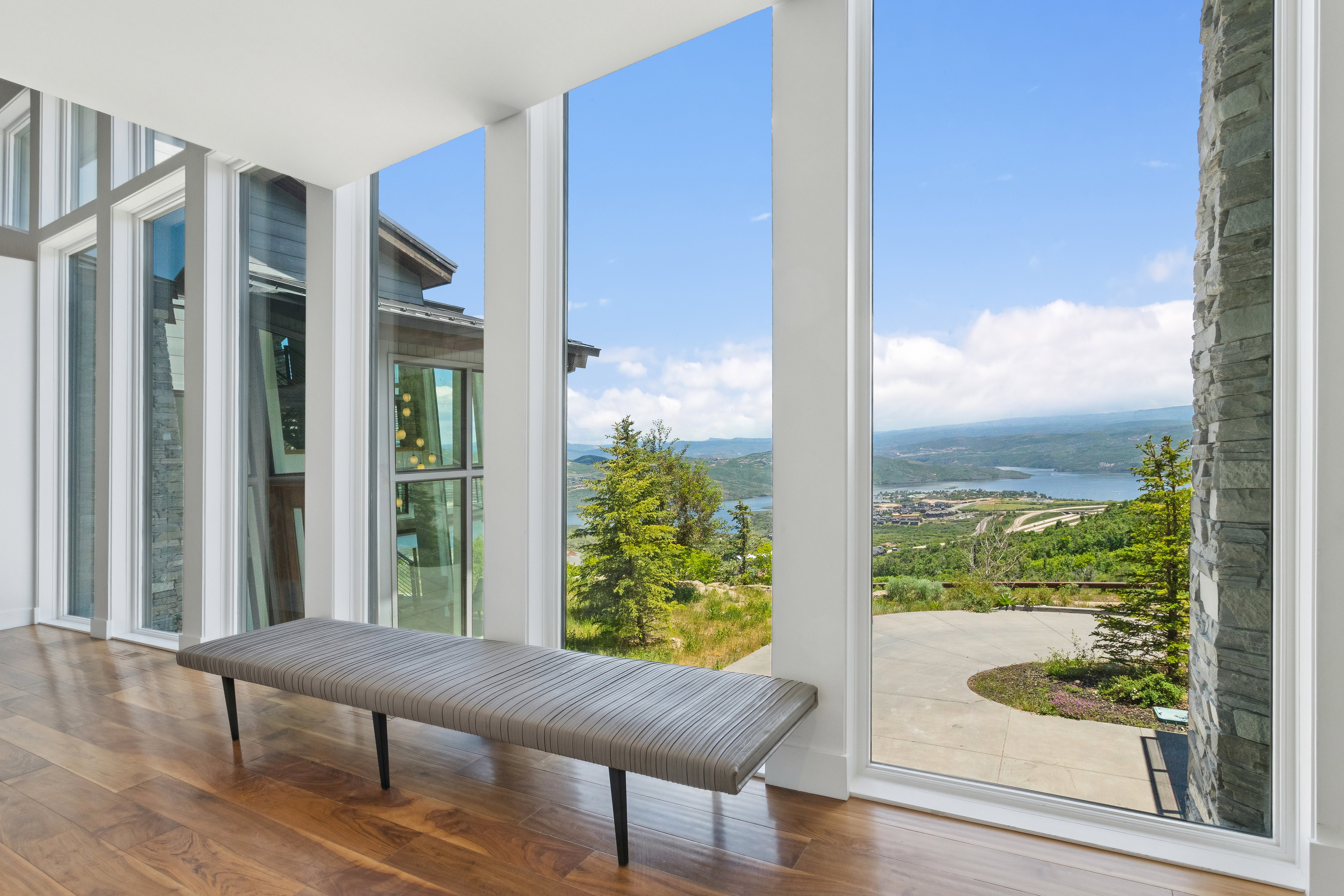 Floor-to-ceiling windows featuring a panoramic water and mountain backdrop