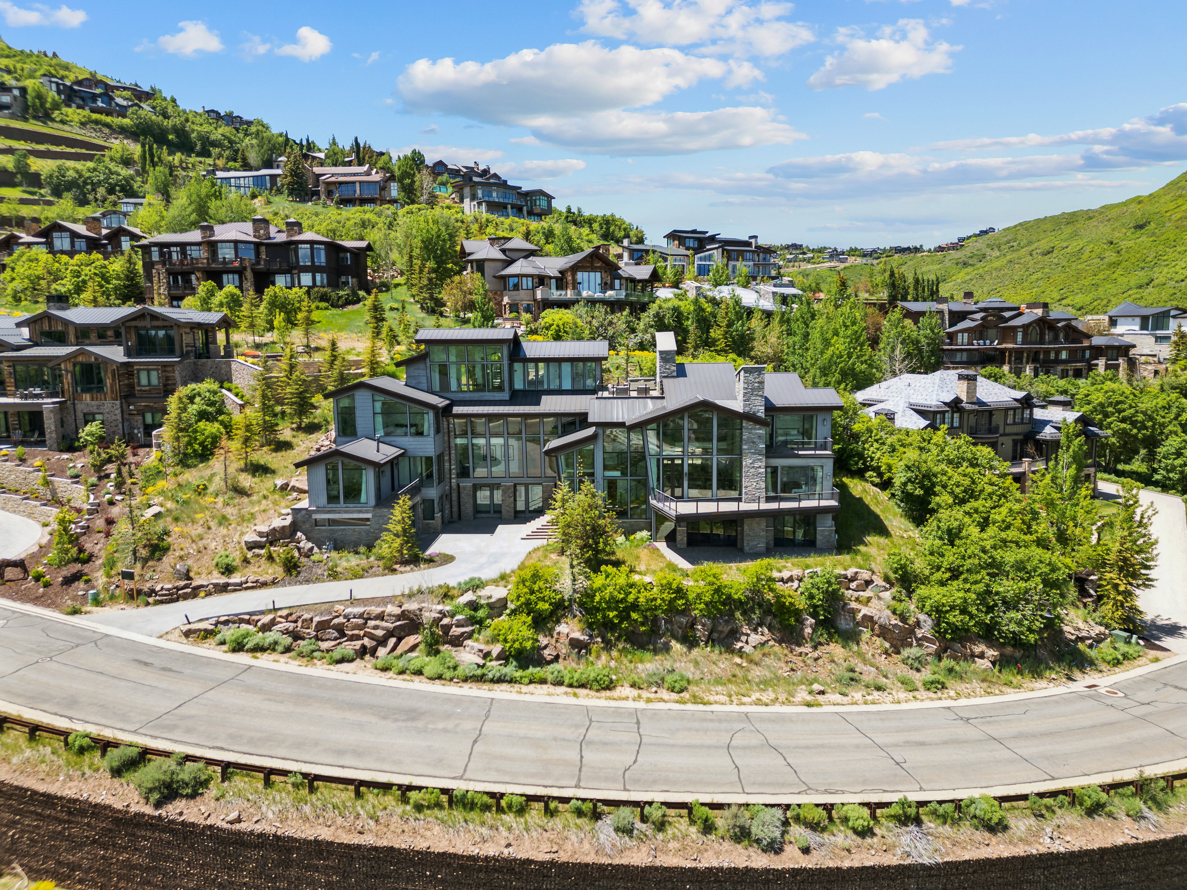 Contemporary residence featuring a multi-level design, extensive glazing, and stone facade elements