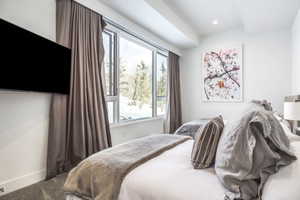 Room with expansive windows, recessed lighting, wall-mounted television, and neutral wall paint