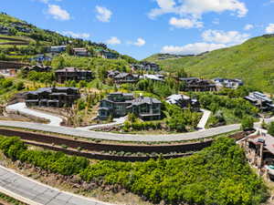 Expansive hillside community featuring multiple residences with varied architectural styles, terraced landscaping, and paved roadways