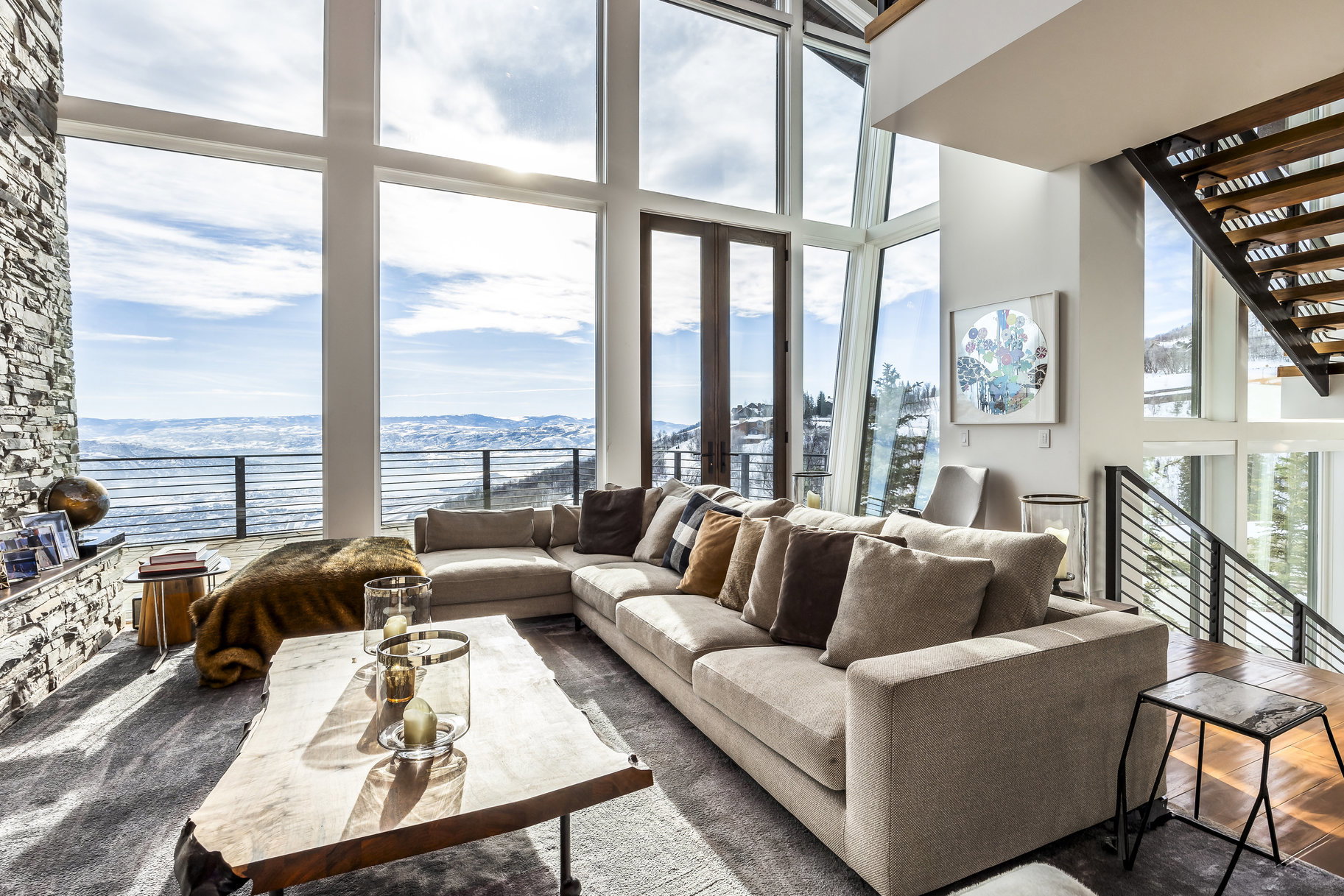 Expansive living area with a stone-clad fireplace and large-format windows