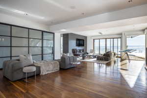 Spacious interior featuring wood-finish flooring, recessed lighting, and a full wall of bi-fold glass doors