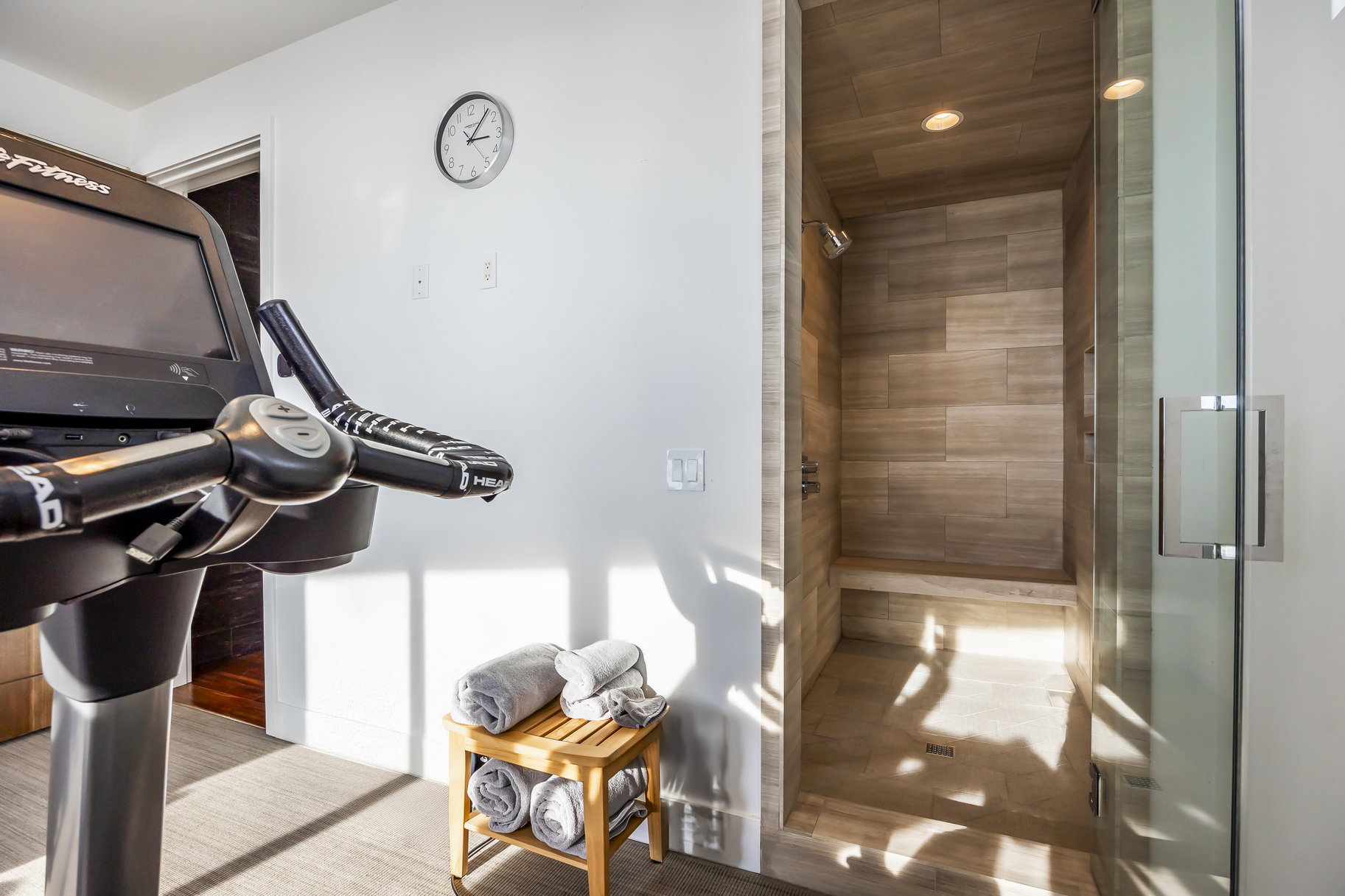 Walk-in shower featuring tiled walls, built-in bench seating, and a glass enclosure with a metal handle