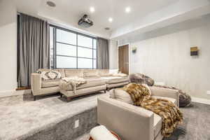 Dedicated media room featuring a large projection screen, integrated ceiling speakers, and recessed lighting