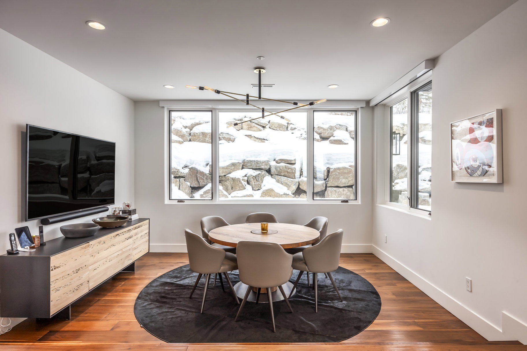 Dining area with wood-finish flooring and a contemporary chandelier