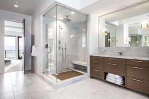 Contemporary bathroom featuring a spacious glass-enclosed shower with a bench, dual shower heads, and marble-style tiling