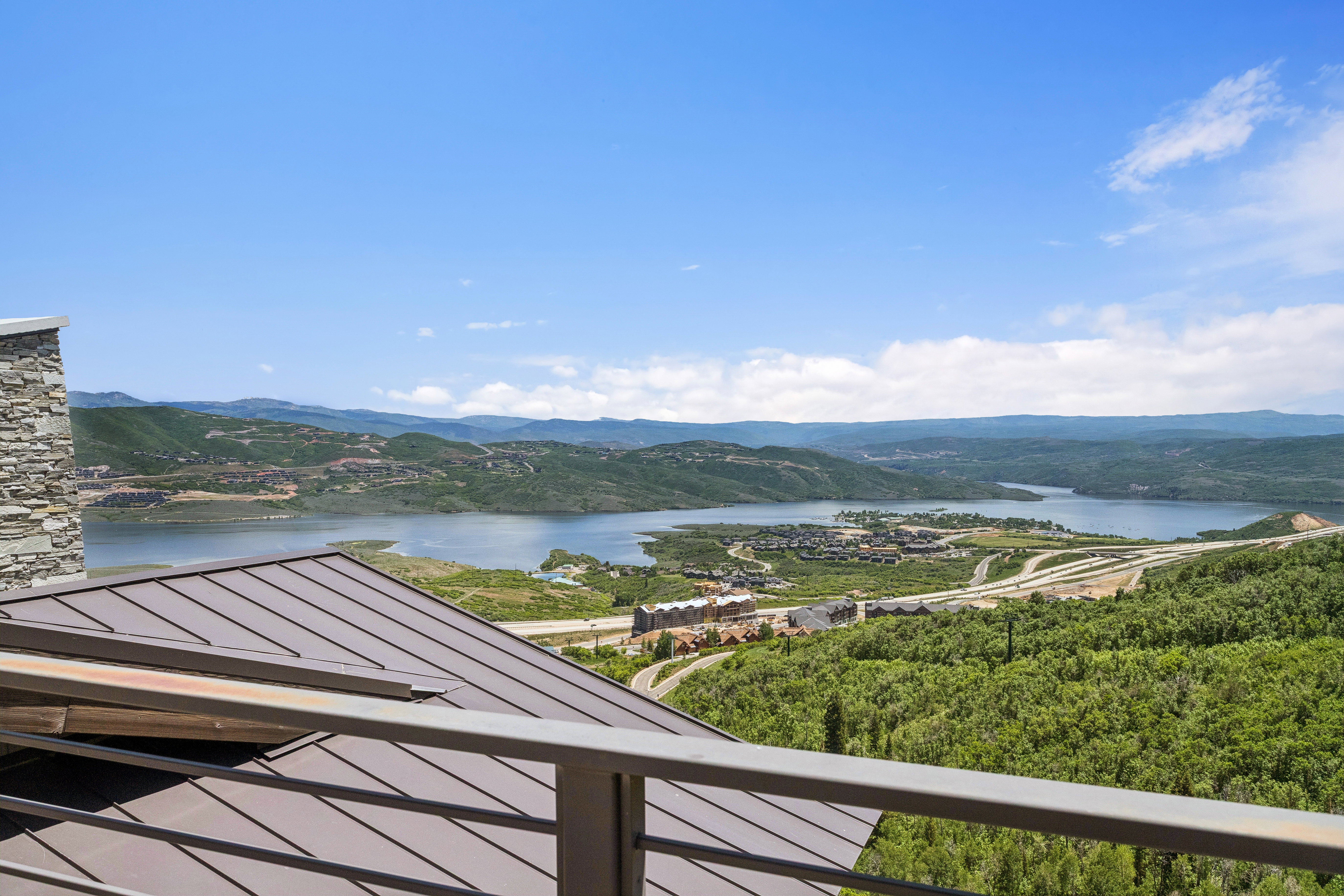 Expansive landscape featuring a large body of water, distant hills, and wooded terrain