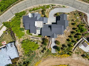 Architectural residence featuring a multi-level dark metal roof and a winding concrete driveway