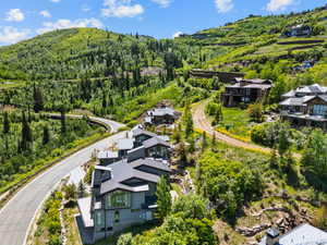 Modern mountain architecture featuring multiple structures with dark grey siding and stone accents