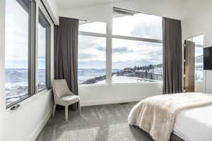 Expansive window wall with panoramic mountain and lake scenery