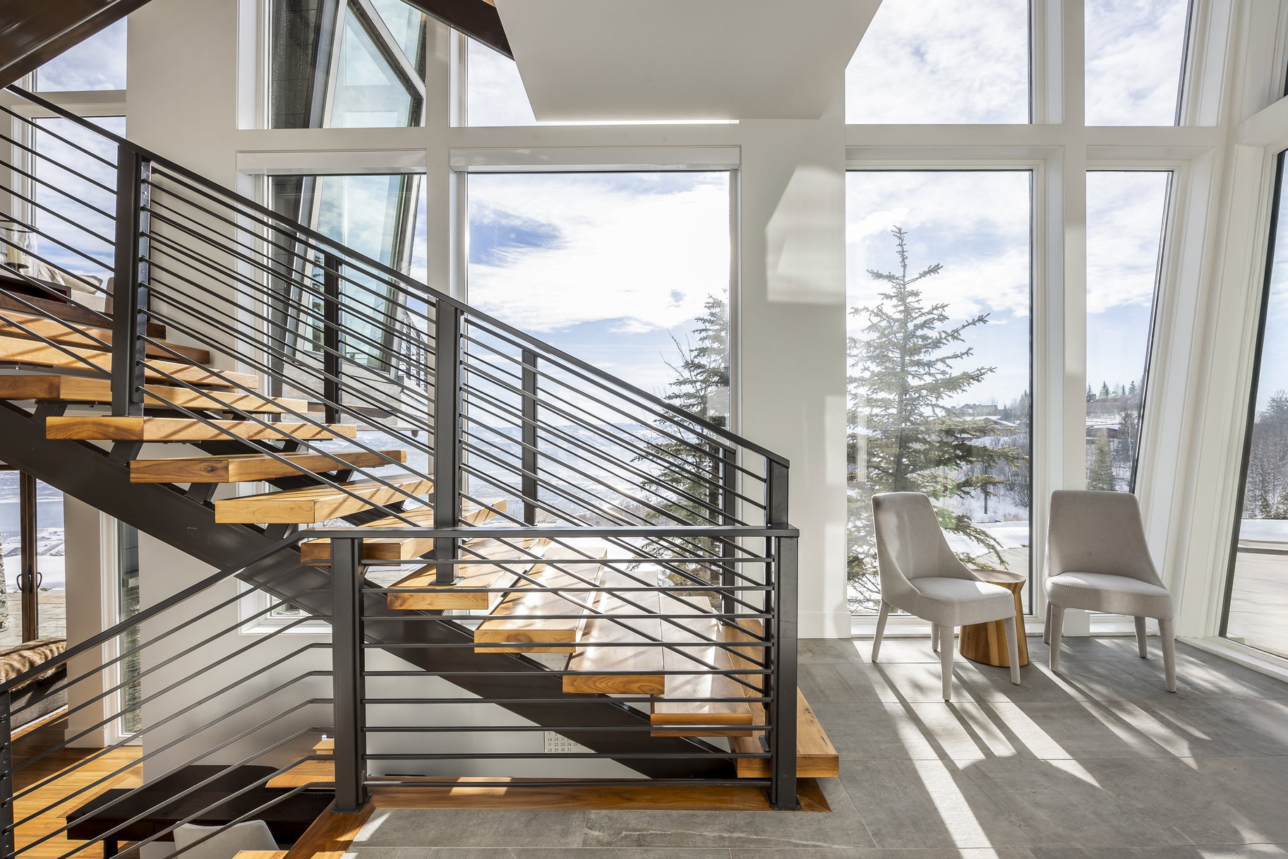 Modern open-tread staircase with wood-finish steps and metal railing