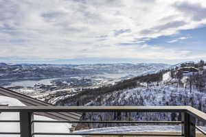 Expansive mountain and lake scenery from a contemporary balcony featuring metal railings