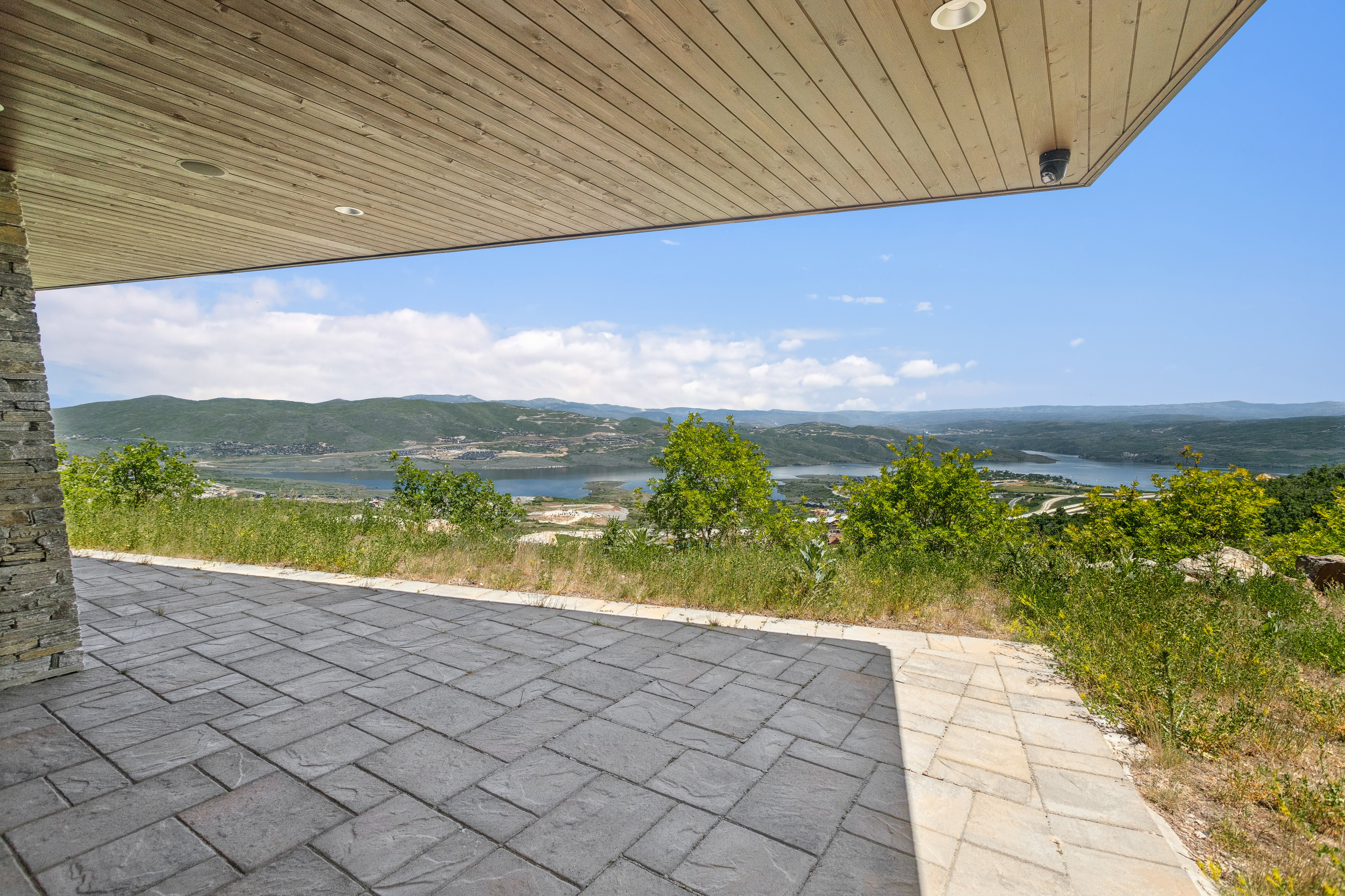 Expansive outdoor patio area featuring stamped concrete flooring and a wood-finish ceiling