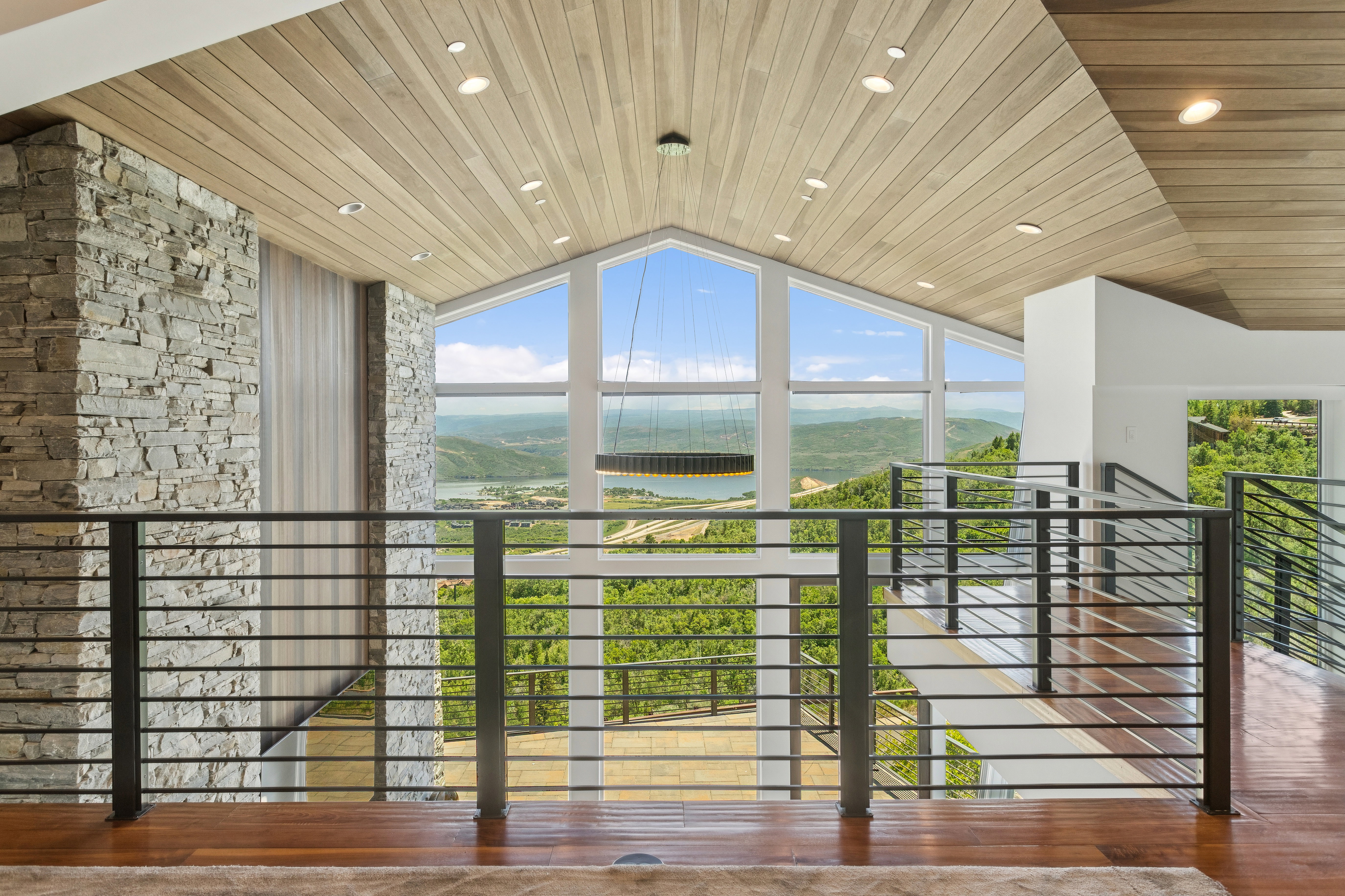 Open concept interior featuring a vaulted wood-finish ceiling, recessed lighting, and a linear chandelier