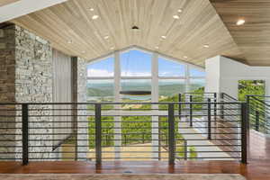 Open concept interior featuring a vaulted wood-finish ceiling, recessed lighting, and a linear chandelier