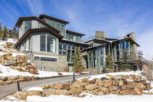 Contemporary multi-level residence featuring extensive stone cladding and vertical siding