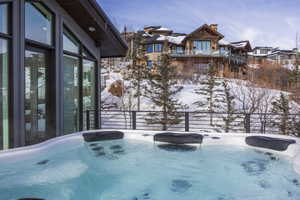 Outdoor spa with integrated headrests and a surrounding snow-covered landscape