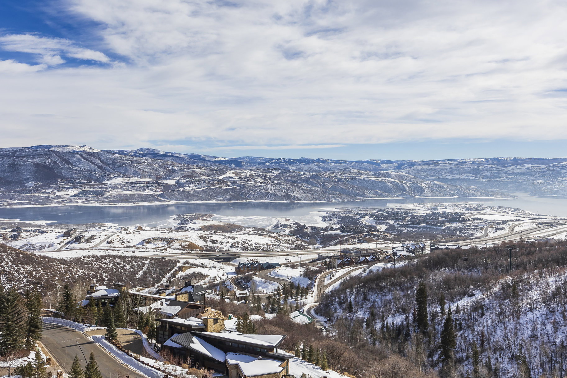 Expansive mountain and lake scenery featuring snow-dusted terrain
