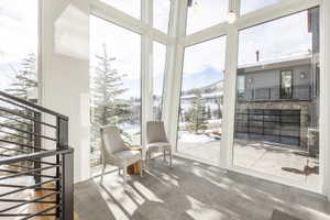 Expansive floor-to-ceiling windows with white framing, offering broad outdoor scenery
