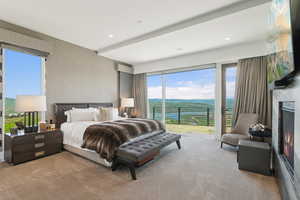 Bedroom with expansive sliding glass doors opening to a scenic mountain and lake backdrop