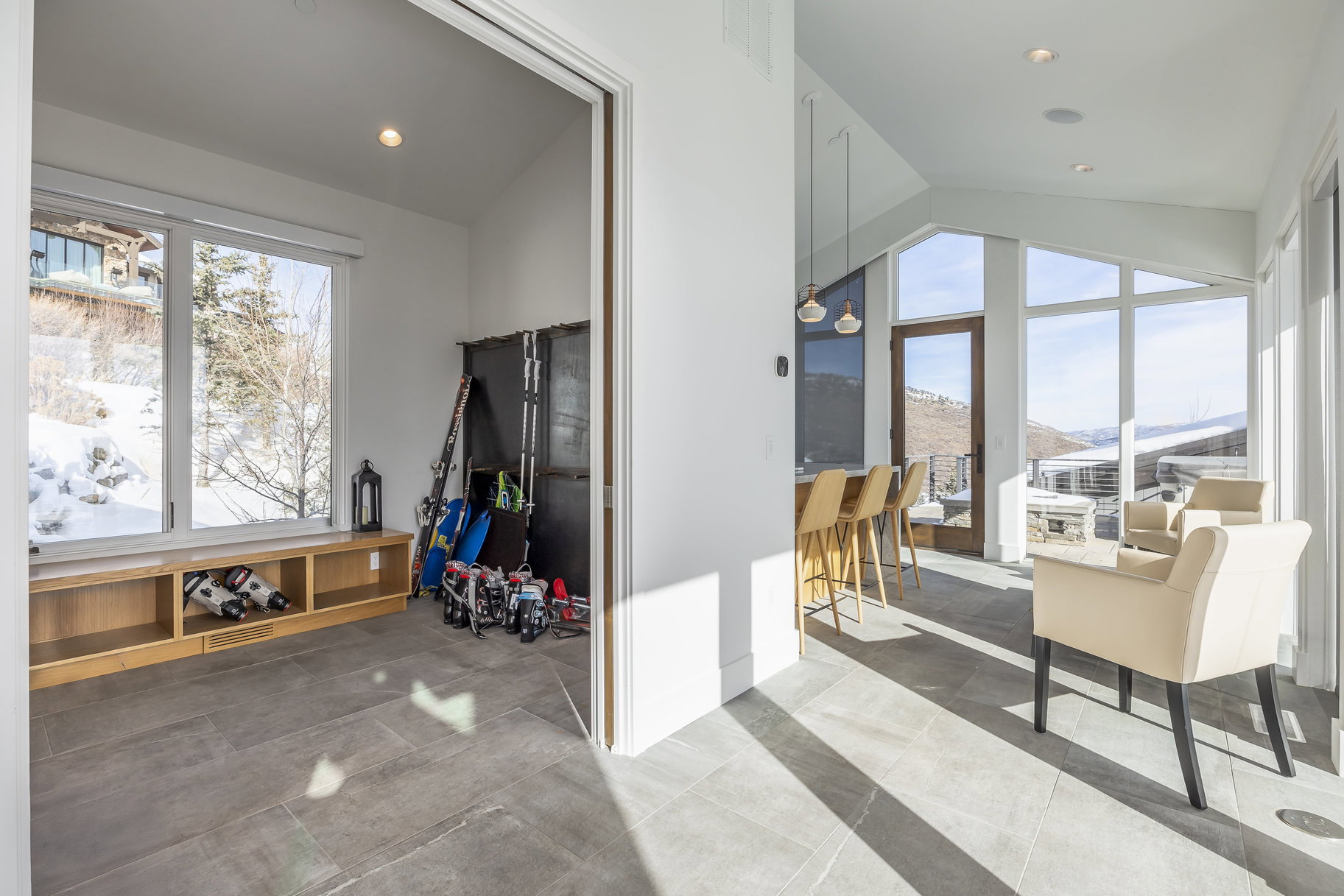 Spacious interior featuring a built-in window bench with open shelving, large windows, and sloped ceilings