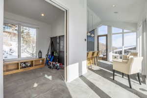 Spacious interior featuring a built-in window bench with open shelving, large windows, and sloped ceilings