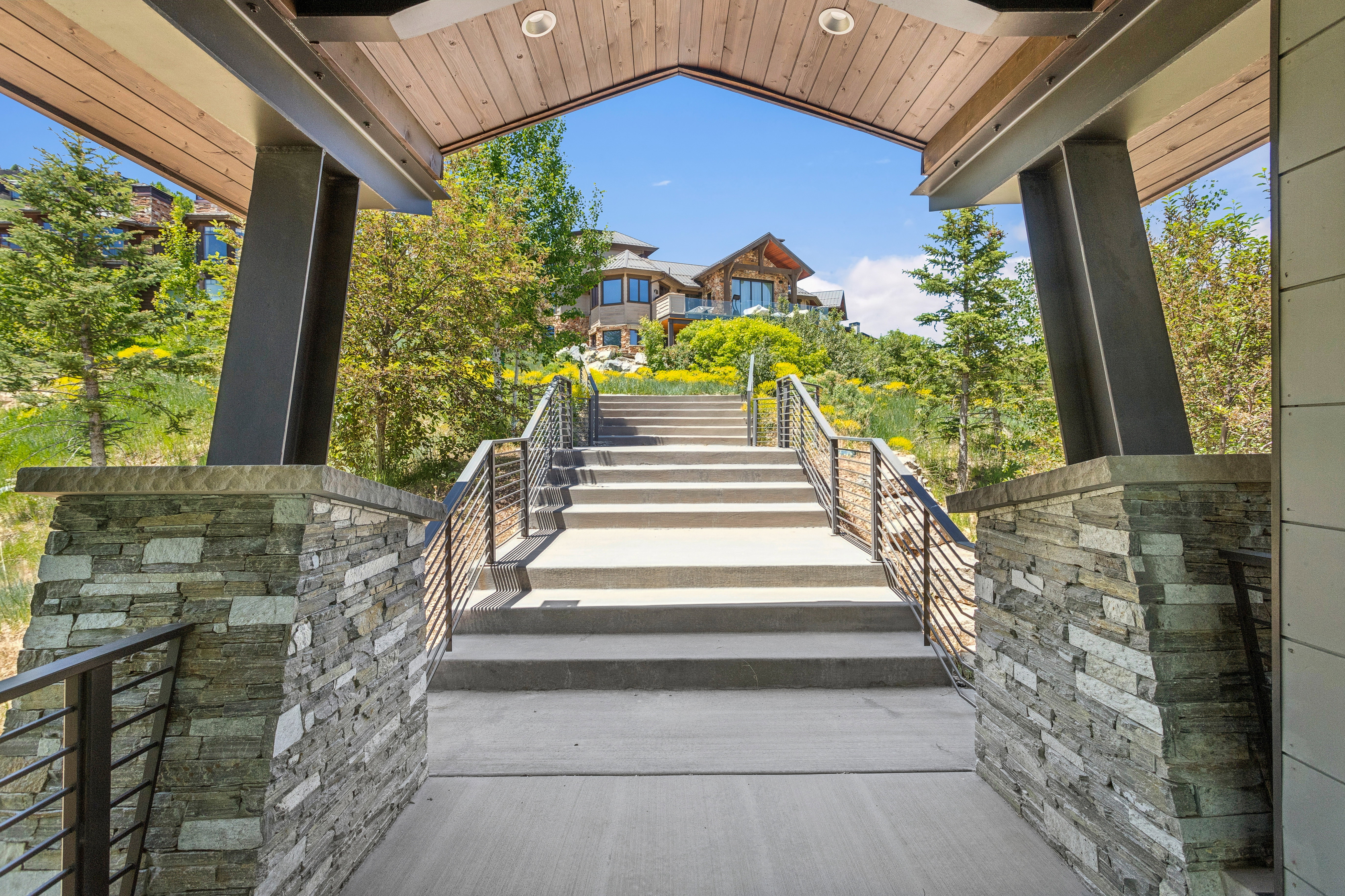 Inviting entry features a stone-clad pillar, wood-finish ceiling, and recessed lighting