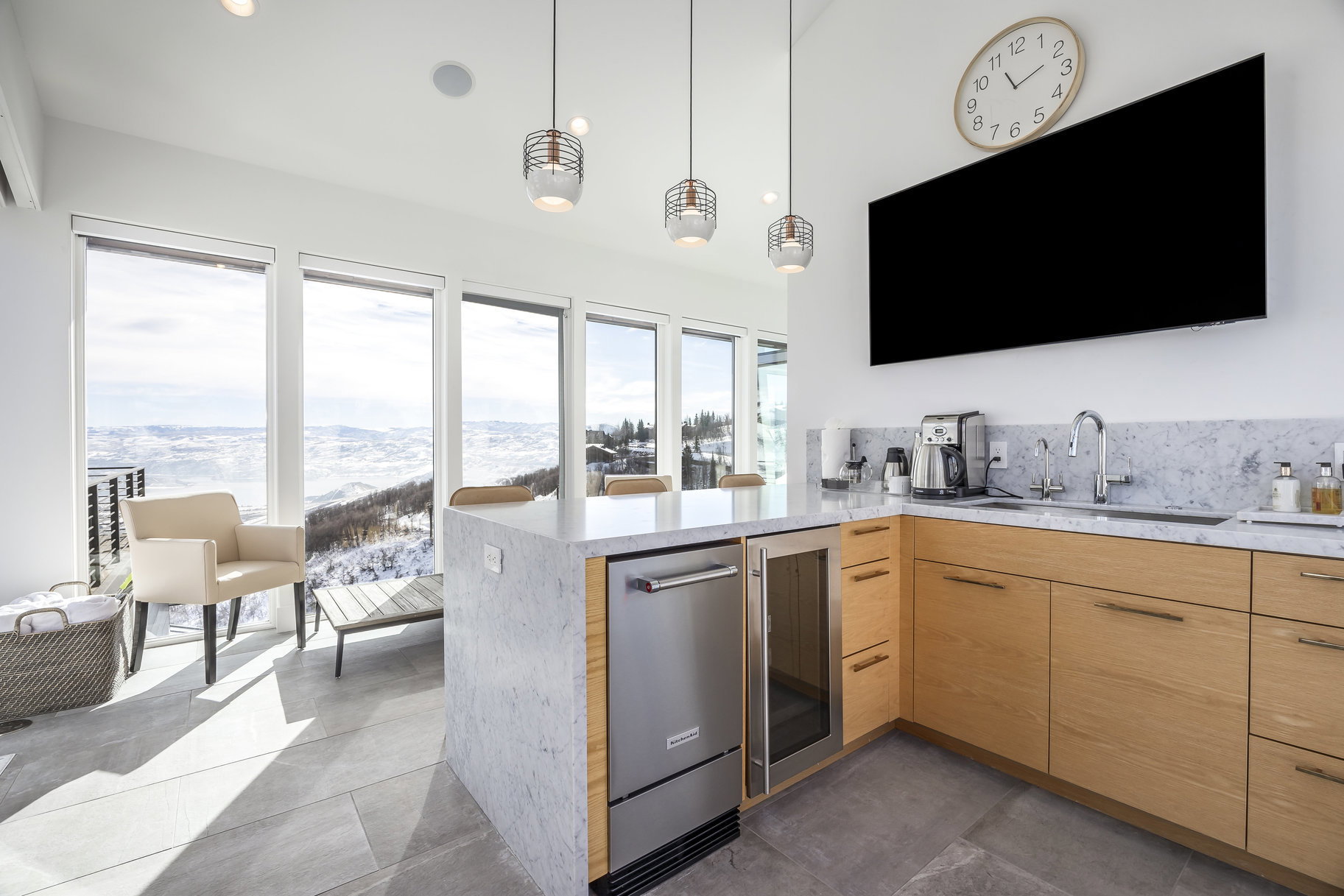 Modern kitchen featuring light wood cabinetry, stone countertops, and a built-in beverage refrigerator